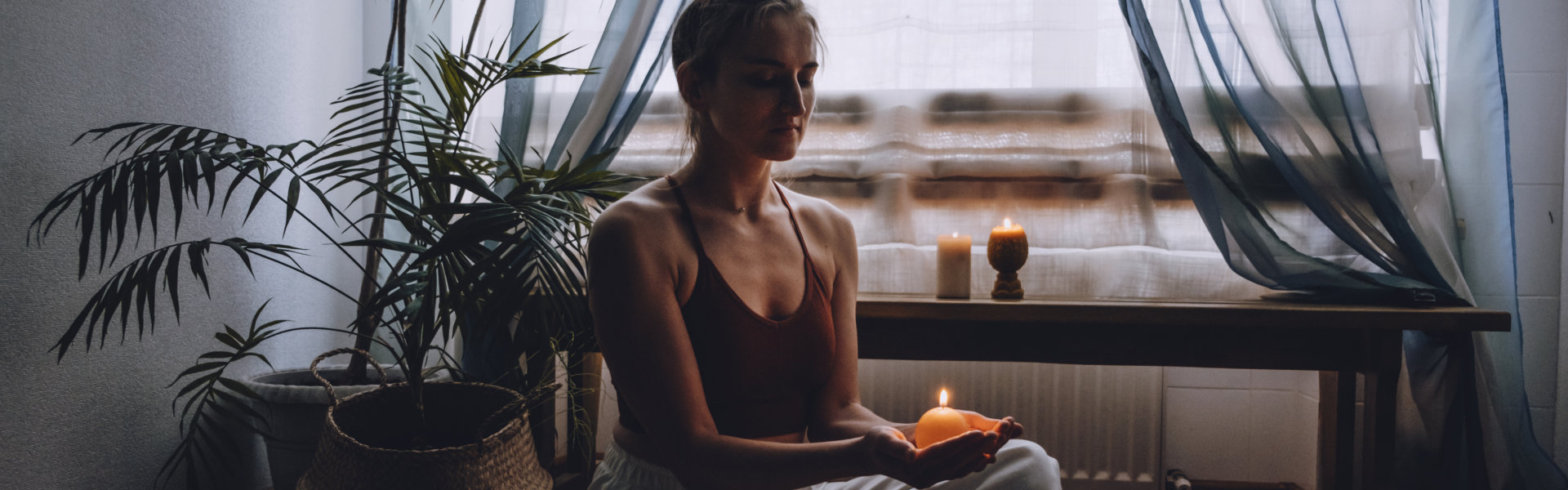 Woman meditating while holding a candle